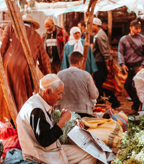 hombre sentado leyendo el periódico en un mercado de Marrakech